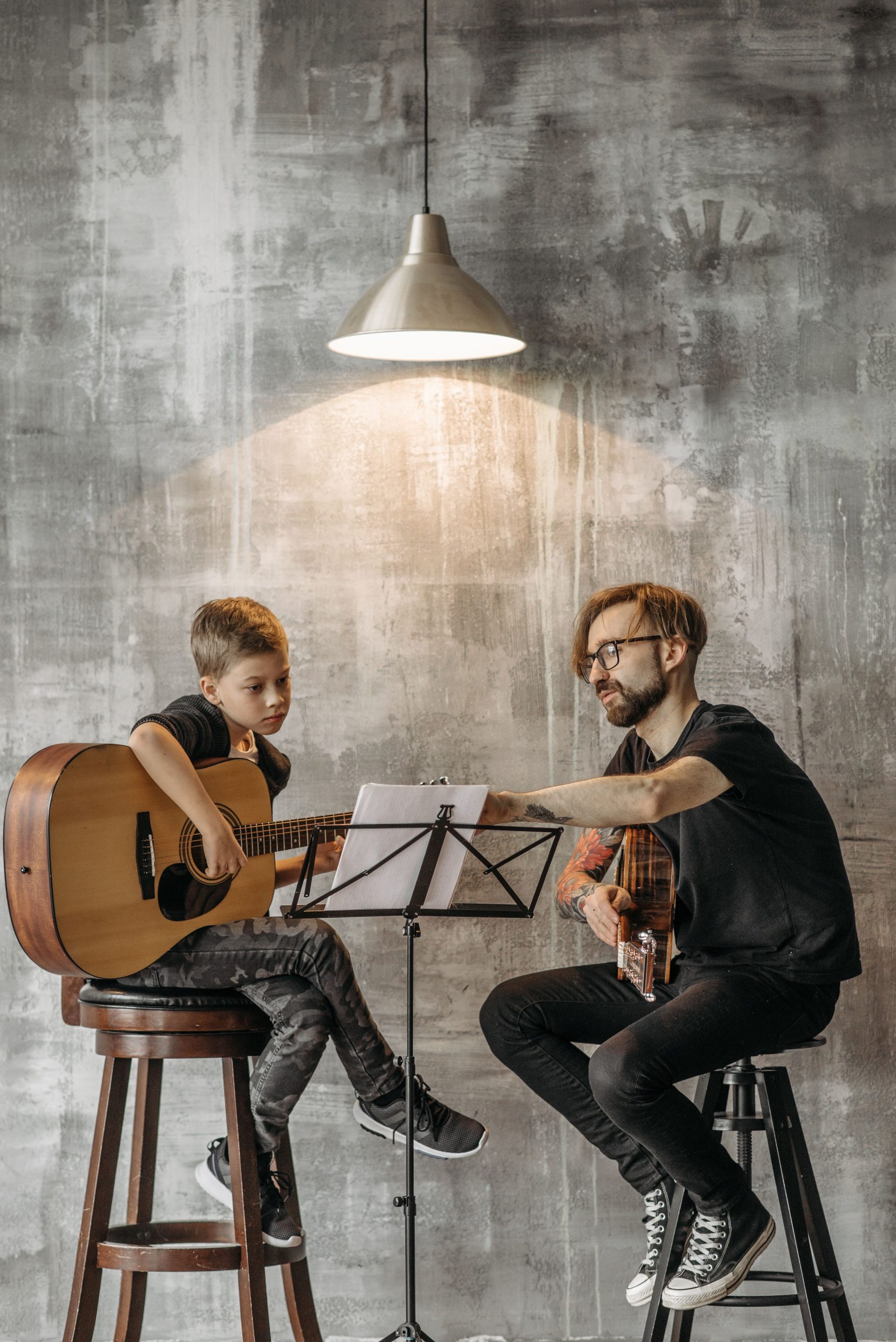 Profesor enseñando guitarra a un alumno joven en una clase de música